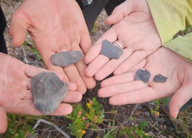 lithic flakes held in the palm of an archaeologists hands