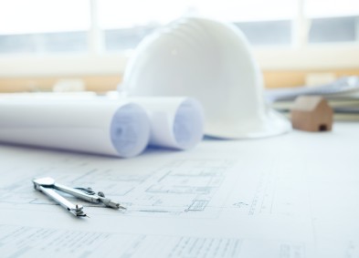 picture of a drafting document hard hat and more tools of the trade on a desk